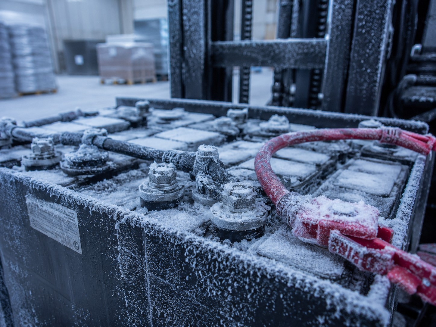 Industrial battery terminals with frost accumulation, illustrating the damage and internal resistance increases caused by sub-zero temperatures in forklift batteries. Industrial battery terminals with frost accumulation, illustrating the damage and internal resistance increases caused by sub-zero temperatures in forklift batteries.