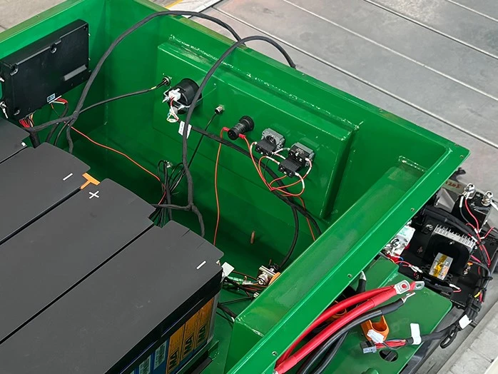 Battery case interior with connector panel Interior of a green steel battery case with cell modules, a connector panel and power cables